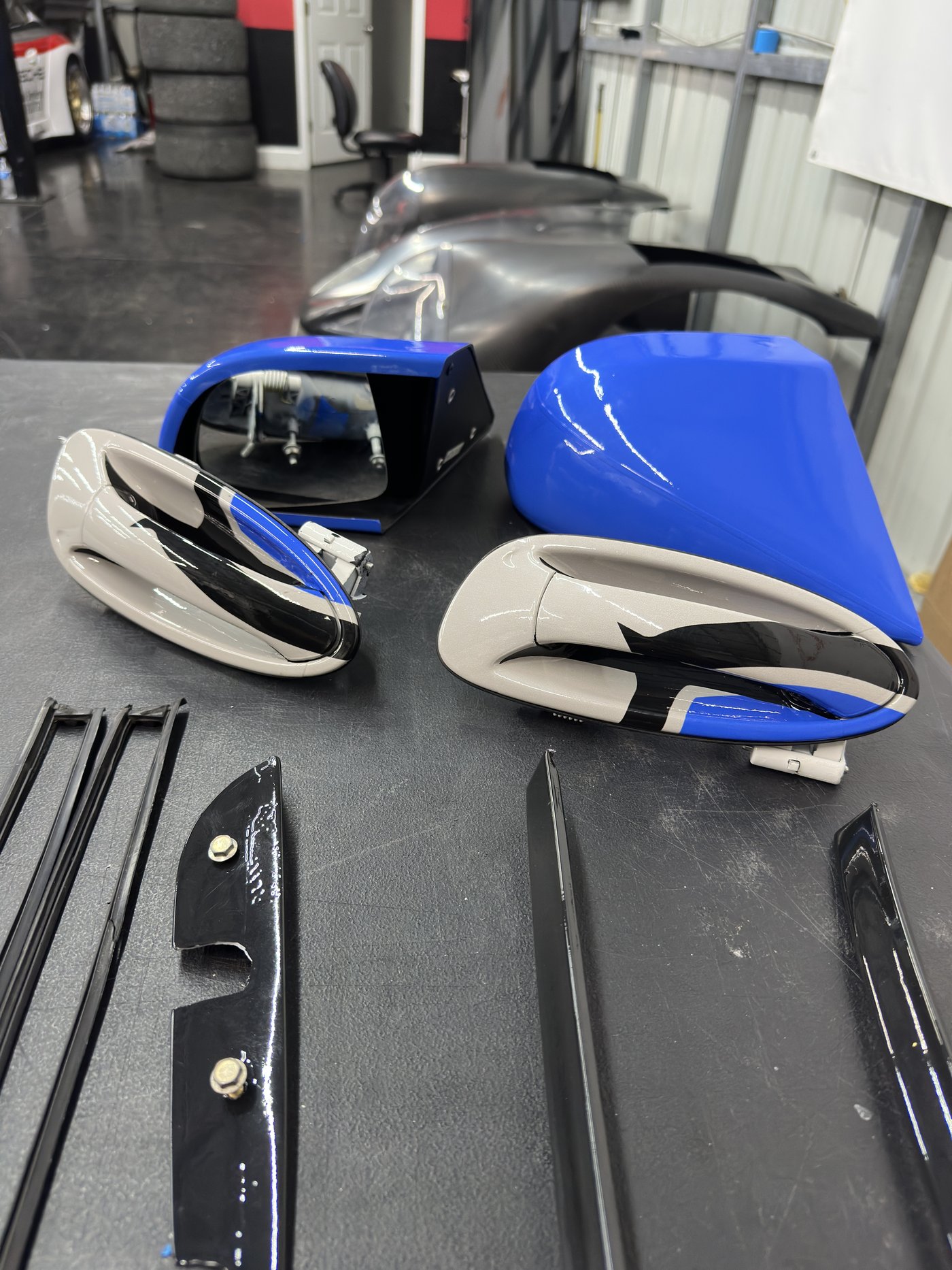 Race car mirror assemblies being wrapped